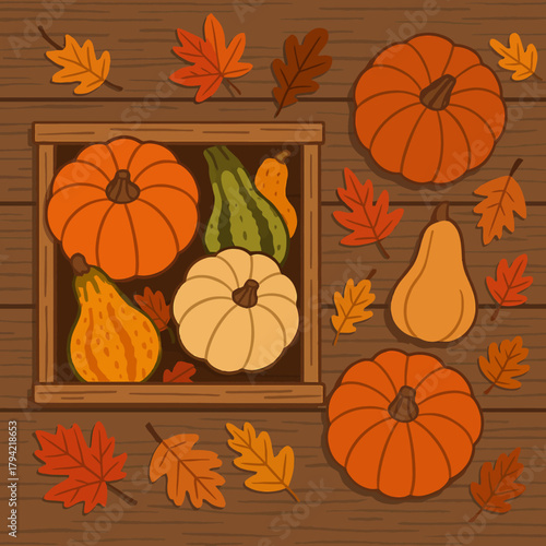 Autumn harvest display of pumpkins gourds and leaves on a wooden surface background