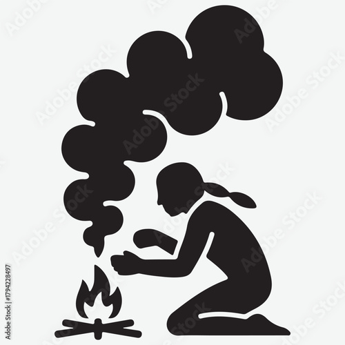 Silhouette of a person making a fire with smoke rising