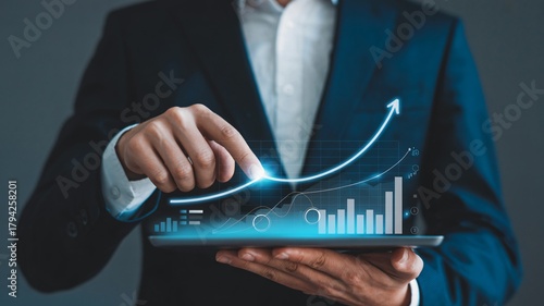 Professional businessman analyzing growing financial graph on tablet, showcasing impressive upward trend and business success with modern technology.