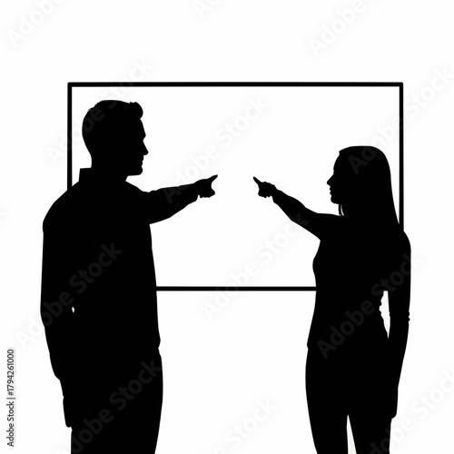 Silhouette of two people pointing at each other in front of a white board.
