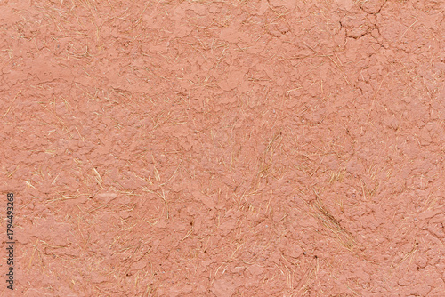 Traditional adobe wall texture made of clay and straw in natural light, Pisac, Písac, Sacred Valley, Cusco, Peru. Rustic earthen material background for architecture and design.