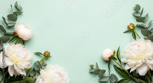 Elegant floral arrangement featuring white peonies and eucalyptus on a pastel green backdrop