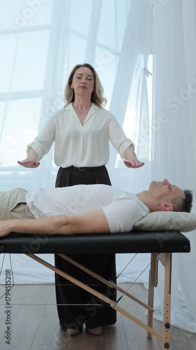 Theta Healing session with practitioner performing energy work above a client lying on a therapy table