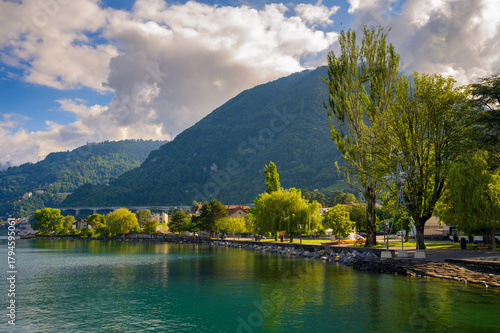 Peaceful lakeside view from Quai des Correspondances in Villeneuve, Montreux region, Switzerland, with Lake Geneva and the Swiss Alps in the background.