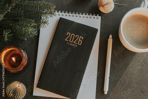 Stylish Desk Setup With 2026 Planner, Notebook, Pencil, Glasses, Fir tree Branch and Coffee on Wooden Surface