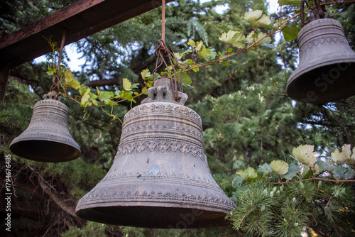 Antique Bells Hanging Among Greenery