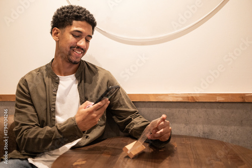 Hispanic man scanning a restaurant's QR code menu.