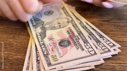 Young woman counting dollar bills, symbolizing inflation, financial crisis and debt
