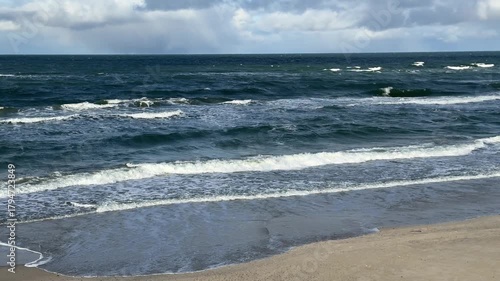 Sunny windy Baltic Sea coastline with waves, dunes and bright sky