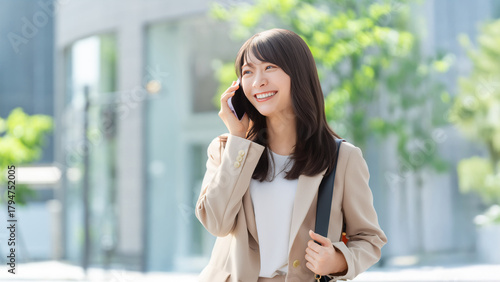 Cuadro en lienzo スマートフォンで通話しながら微笑むビジネスウーマン、屋外のオフィス街, Smiling businesswoman talking on a smartphon