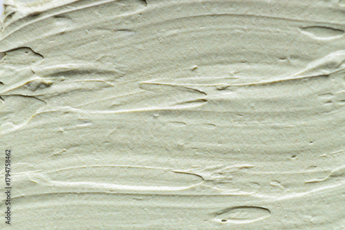 Macro texture of soft green clay mask spread in smooth waves, creamy skincare product surface with natural matte finish ideal for beauty, spa, cosmetic and wellness concepts
