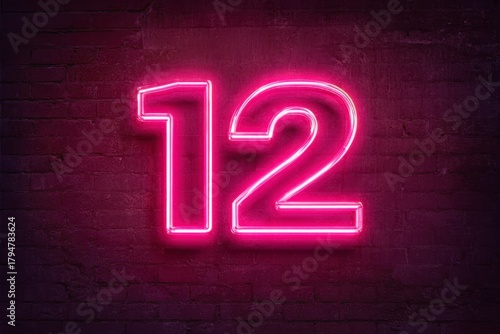 Bright Neon Number 12 on Dark Wall Background in Vibrant Pink Color