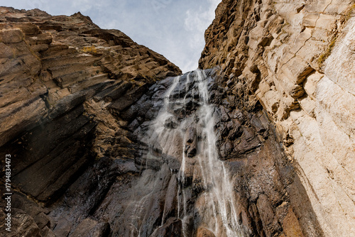 Stunning waterfall cascades down rocky cliffs in Kabardino-Balkaria. The scene captures the natural beauty of the region with clear water and rugged terrain.