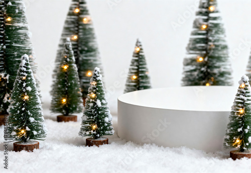 A white podium surrounded by miniature fir trees with lights. The scene is set on a snowy surface, creating a festive atmosphere for product advertising.
