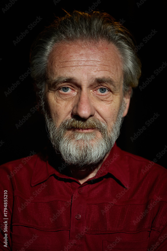 Obraz premium Older man in red shirt waiting for something on night city location