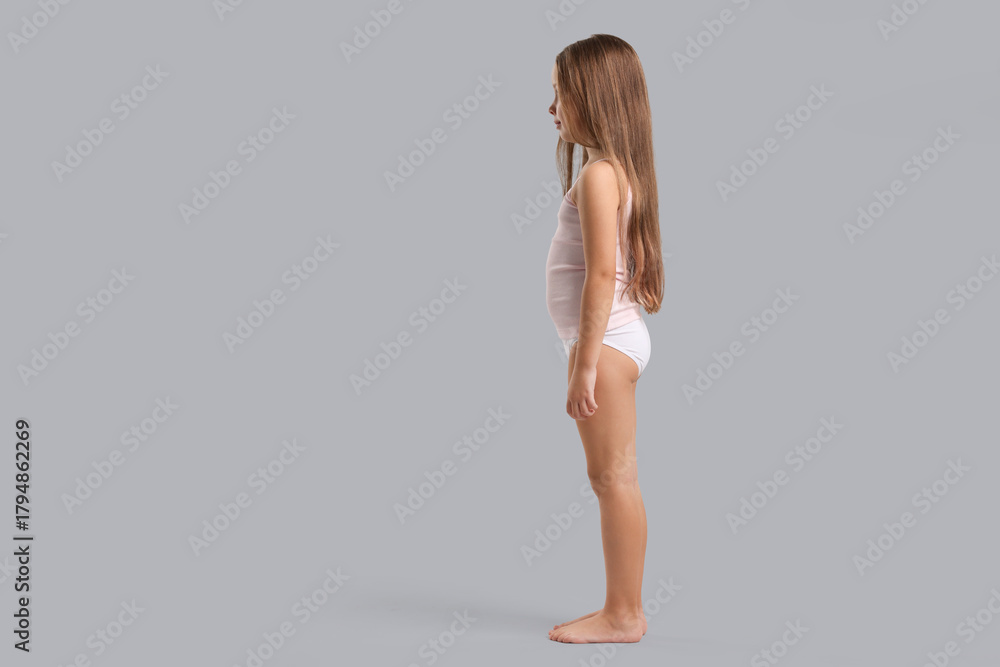 Fototapeta premium Little girl in underwear on light grey background. Space for text