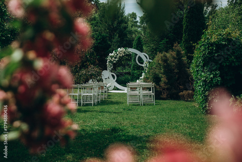 Beautiful outdoor wedding ceremony setup with floral decor and chairs in lush garden