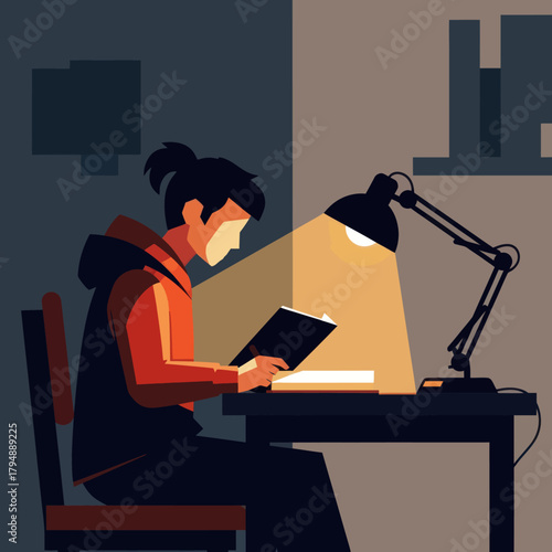 Focused student in a red hoodie reading a book at a desk under a bright lamp at night.