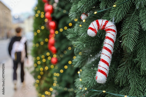 New Year decorations in city, candy cane blurred golden lights on a street on people background