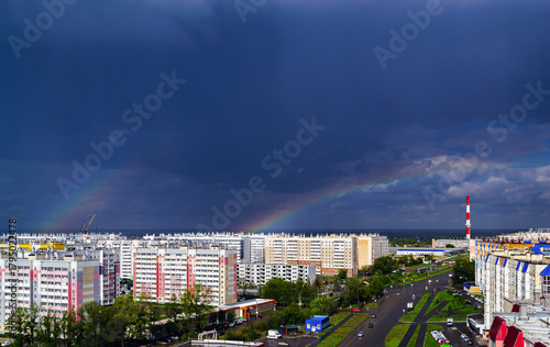 Double rainbow over city buildings after rain