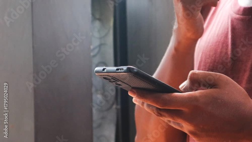 Asian man is typing on a smartphone secretly in the corner