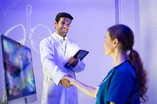 handshake between Hispanic doctor and caucasian woman doctor in medical office. Clinic, healthcare and professional deal shaking hands with agreement