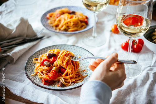 Friends having a pasta dinner with wine at home.