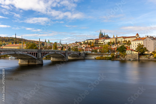 Autumn Panorama of Prague Castle Above the Vltava River with Historic Bridges and the Cityscape of Prague, Czech Republic, Captured in Warm Fall Colors During a Calm Scenic Evening