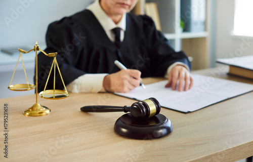Foto Woman judge signs legal document in courtroom
