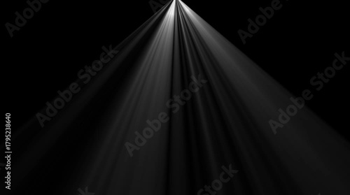 Dramatic spotlight beams piercing through darkness ethereal light rays emanating from above creating a sense of mystery and focus abstract light effect for cinematic backgrounds and visual effects