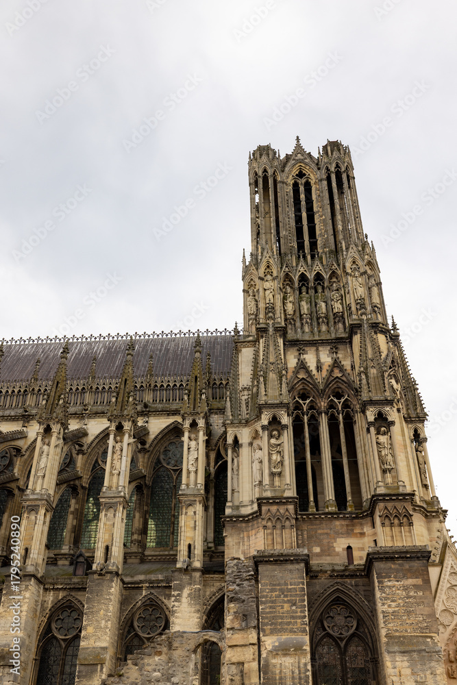 Fototapeta premium Reims, Marne, Grand-Est, France, August, 28th, 2025, Champagne Area, Gothic structure details, Photograph showcasing grandeur of Gothic architecture with intricate stonework and vertical