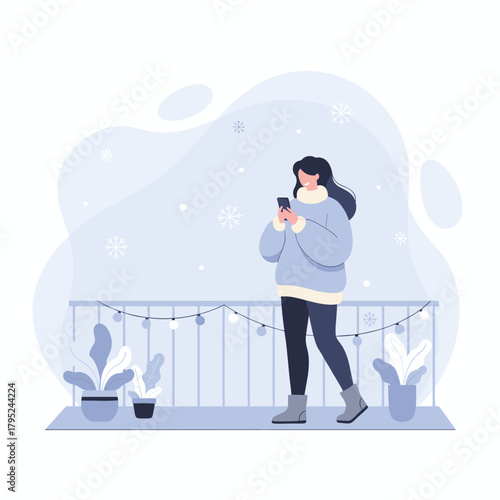 Cozy woman uses phone on a snowy balcony with festive lights Winter leisure and communication
