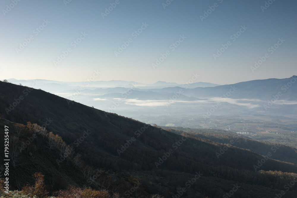Naklejka premium 影の山腹と眩しく輝く雲海かかる山麓地域