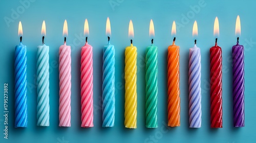 A colorful row of birthday candles are brightly lit on a blue background creating a vibrant scene full of celebration and joyful wishes.