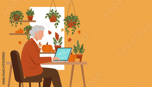 Senior man working remotely on a laptop at a cozy fallthemed desk Business and autumn concept