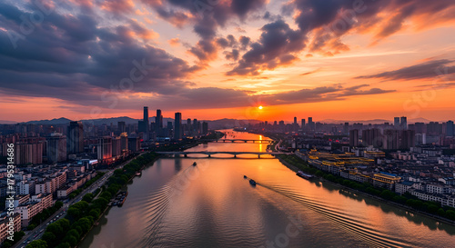 Fototapeta Naklejka Na Ścianę i Meble -  Vibrant sunset over a city river and skyline