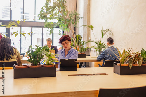 People working in biophilic modern coworking office with plants