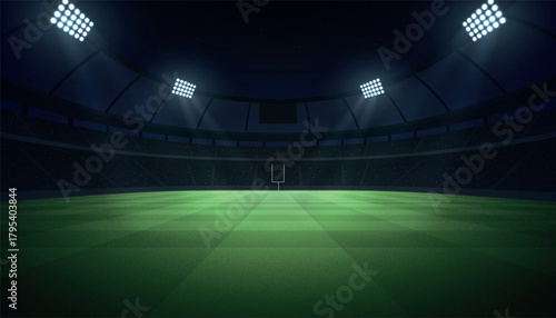 Illuminated football stadium at night with grass field, goal post, and spotlight beams.
