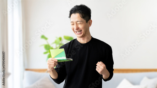 通帳を見て喜ぶ男性