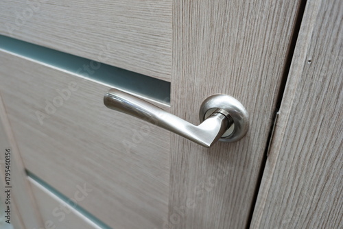 Modern door handle on a wooden cabinet in a contemporary living space showcasing functional design and elegant simplicity