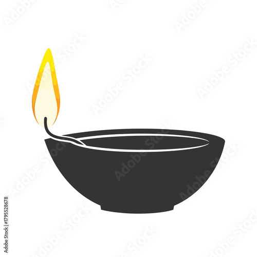 A silhouette of a traditional indian oil lamp, a diya, with a bright flame, isolated on a