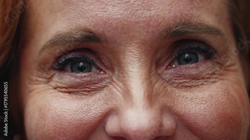 Extreme close-up of middle-aged woman smiling softly with expressive eyes and visible laugh lines conveying warmth and optimism, natural light emphasizing authenticity