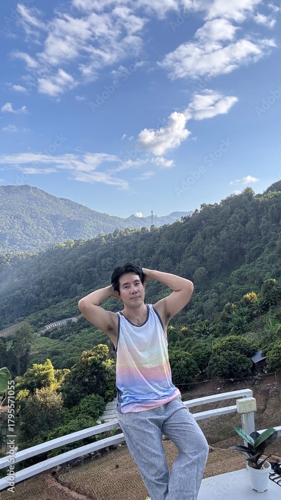 Naklejka premium Handsome Man Relaxing on a Camping Trip with Scenic Green Mountain View