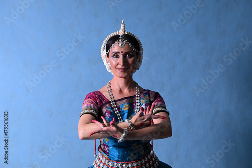 Indian dancer in the studio on a blue background in a dance pose