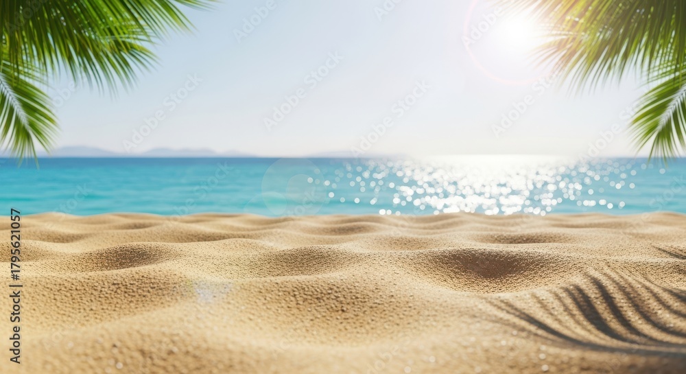 Fototapeta premium A pristine tropical beach scene with golden sand in the foreground, turquoise ocean water sparkling under a bright sunny sky, framed by lush green palm leaves