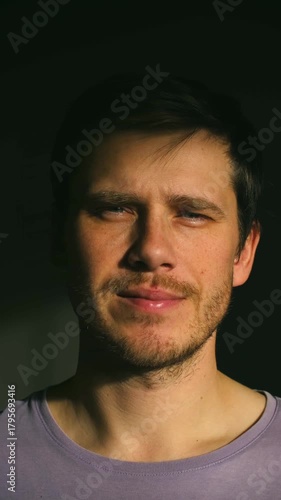white man close-up under warm sunlight, subtle smile, soft stubble, lavender tee, dark background, gentle window light, intimate gaze, hopeful mood, lifestyle actor persona, content creator moments