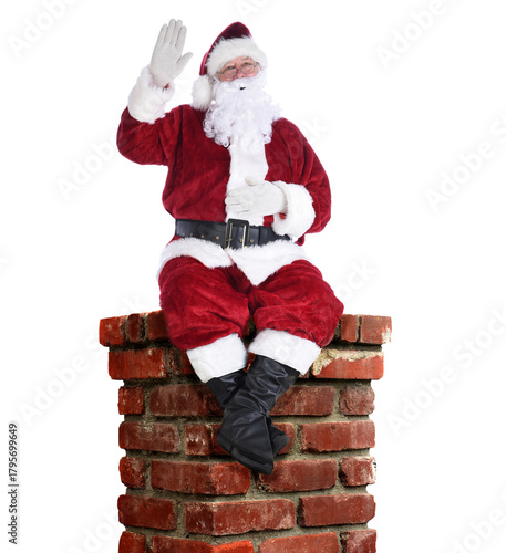 Santa Claus sitting on a chimney waving with one hand isolated on white
