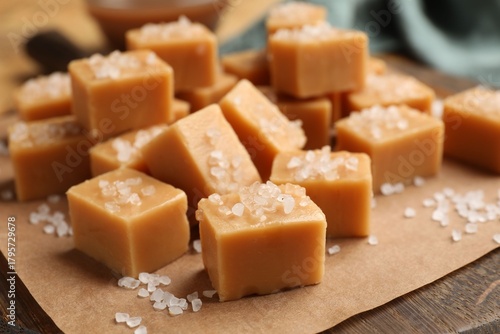 Tableau sur toile Tasty caramel candies with salt on wooden board, closeup