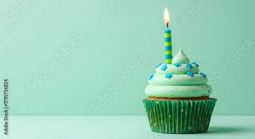 Celebrate with a delicious mint green cupcake topped with a single candle and blue star sprinkles on a modern pastel background