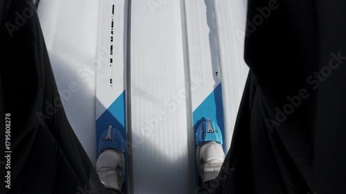 Ski jumper on the skis sliding down a jumping ramp, achieving an explosive jump, flying and landing gently and safely on snow, point of view shot.